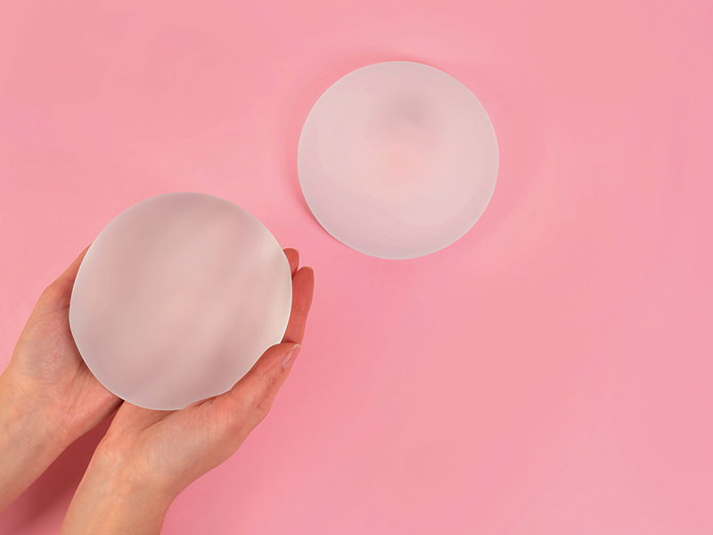 O que é a Lifesil? Mão segurando uma prótese de silicone da Lifesil, e outra apoiada mais para frente.